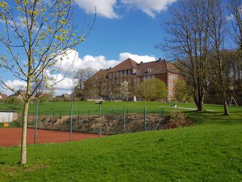 Blick über den benachbarten Tennisplatz zur Gerhart-Hauptmann-Schule